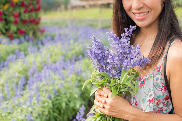Retrato al aire libre de una hermosa mujer de mediana edad de asia. chica atractiva en un campo con flores