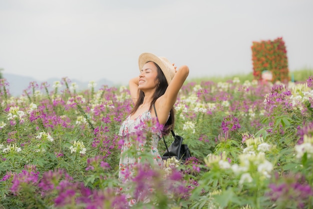 Retrato al aire libre de una hermosa mujer de mediana edad de asia. chica atractiva en un campo con flores