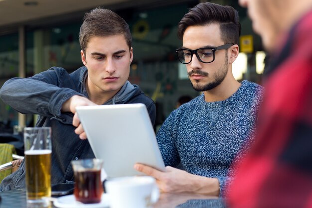 Retrato al aire libre de jóvenes empresarios que trabajan en la barra de café.