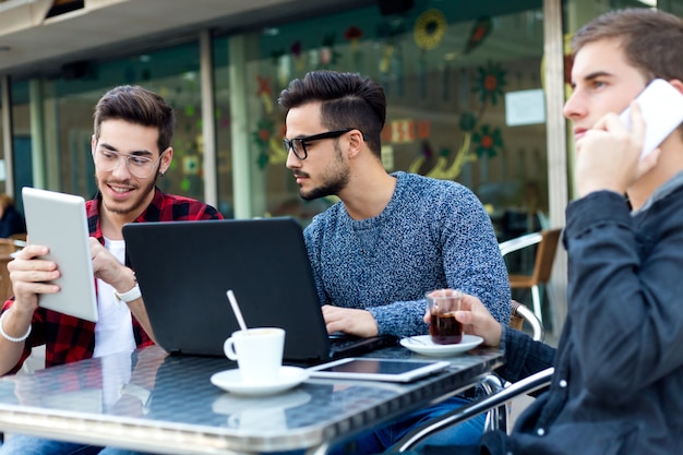 Retrato al aire libre de jóvenes empresarios que trabajan en la barra de café.