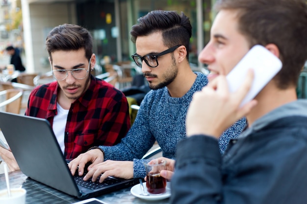 Retrato al aire libre de jóvenes empresarios que trabajan en la barra de café.