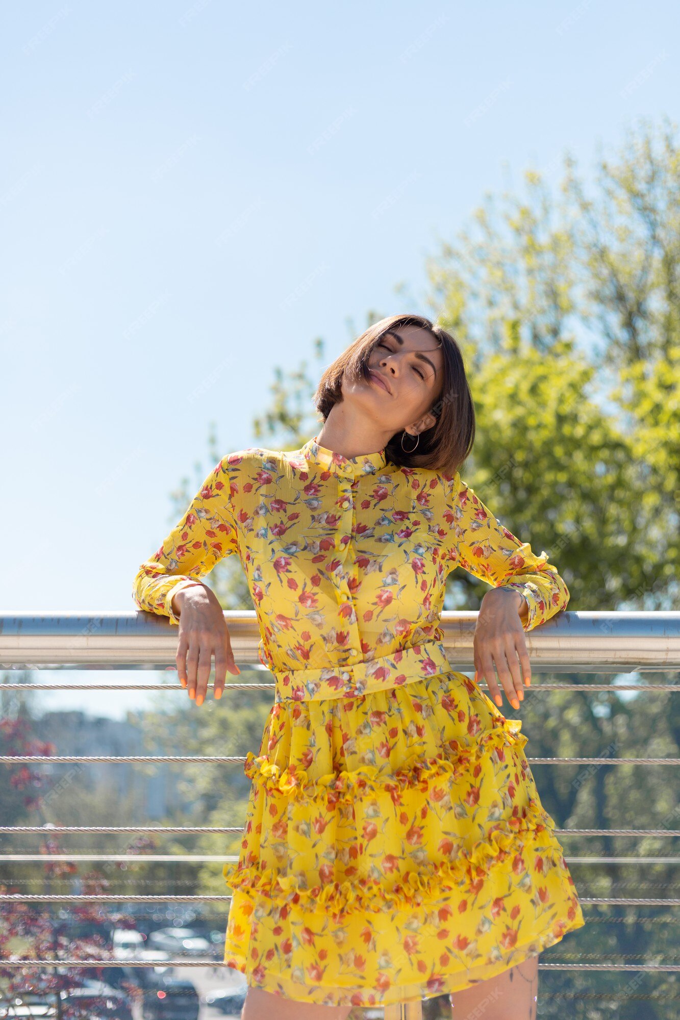 al aire libre de mujer en vestido amarillo de verano posando en el puente, feliz estado ánimo alegre, disfrutando de los días soleados de verano | Foto Gratis