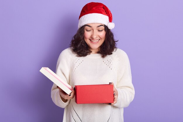 Retrato de alegre bonita morena esperando Navidad