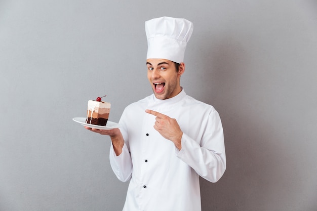 Foto gratuita retrato de un alegre chef hombre vestido con uniforme