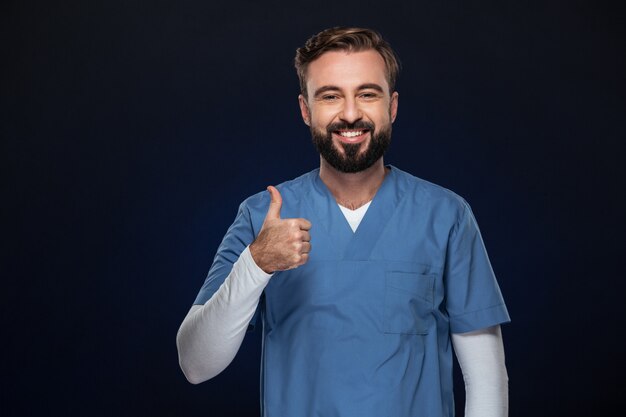 Retrato de un alegre doctor hombre vestido con uniforme