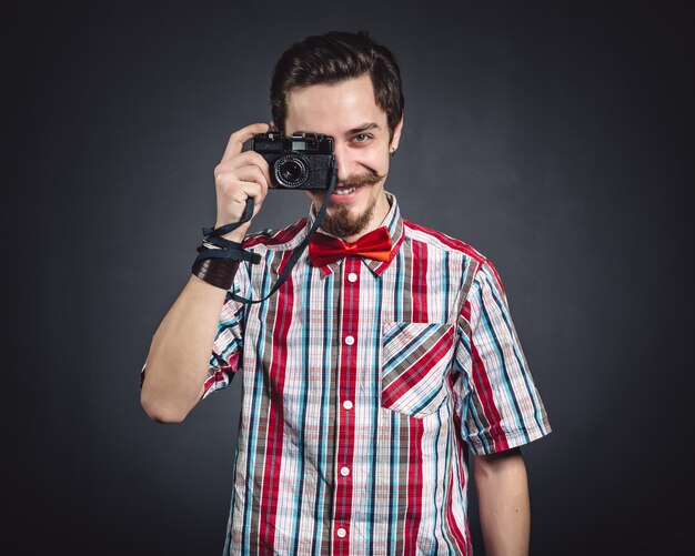 Retrato de un alegre fotógrafo en estudio