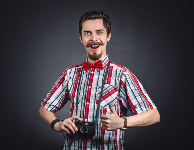 Retrato de un alegre fotógrafo en estudio