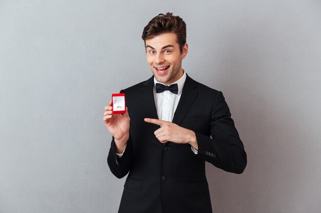 Retrato de un alegre hombre feliz vestido con esmoquin