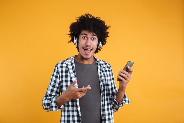 Retrato de un alegre joven africano escuchando música