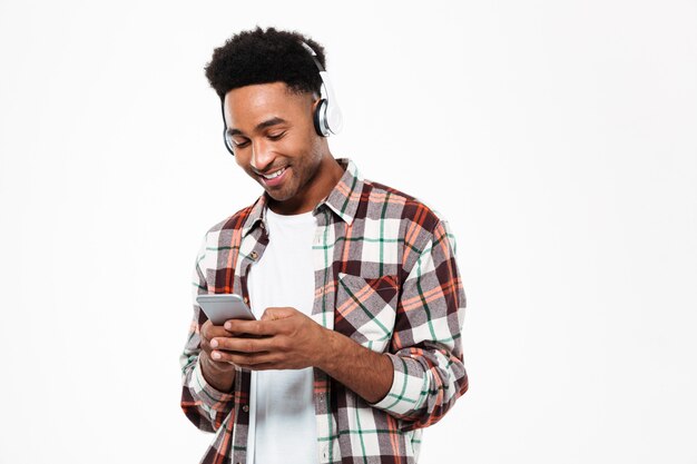 Retrato de un alegre joven afroamericano en auriculares