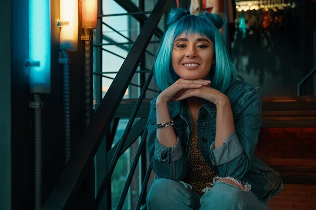 Retrato alegre de la muchacha con el pelo azul elegante y la cara bonita