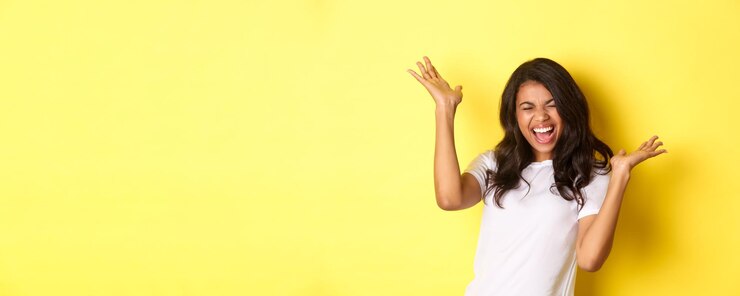 Foto gratuito retrato de una alegre niña afroamericana gritando de alegría y celebrando alcanzar la meta o ganar s