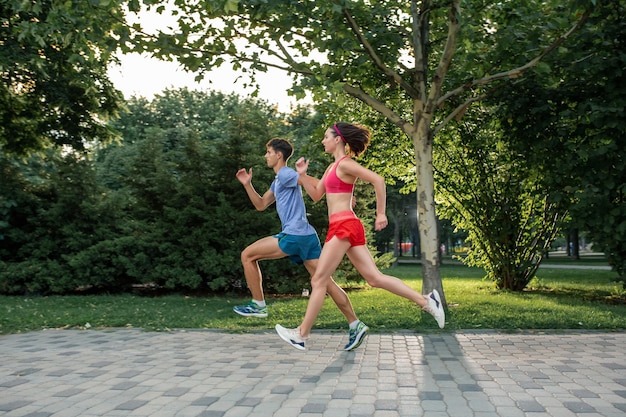 Retrato de una alegre pareja caucásica corriendo al aire libre. Familia deportiva