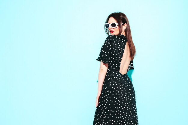 Retrato de alta moda de la joven y bella mujer morena con un bonito vestido de lunares de verano de moda