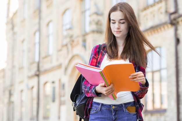 Retrato de alumna con libro en ciudad
