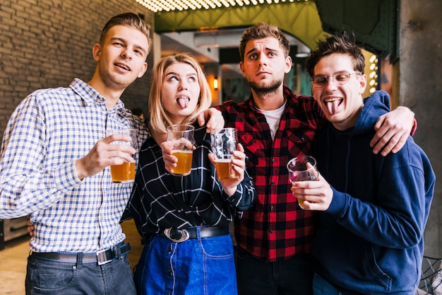 Foto gratuita retrato de amigos sosteniendo los vasos de cerveza