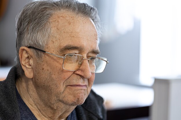 Retrato de un anciano con gafas de cerca.