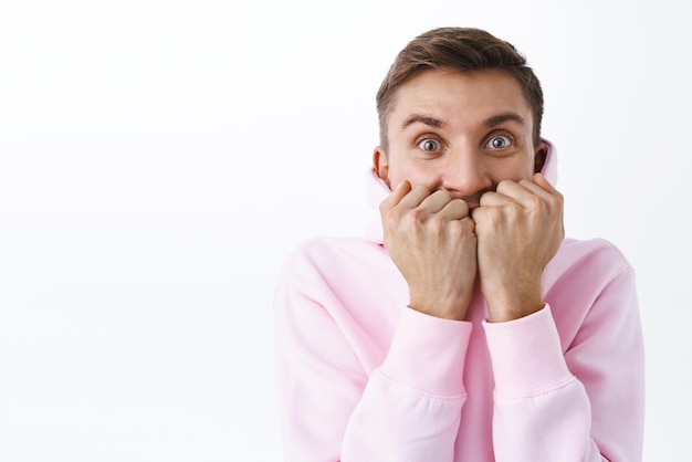 Retrato de un apuesto hombre alegre y entusiasta que se cubre la boca y expresa anticipación y emoción con los ojos no puedo esperar a ver una nueva serie de televisión esperando algo increíble mirando la cámara