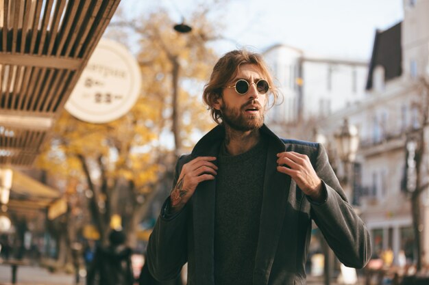 Retrato de un apuesto hombre barbudo con gafas de sol