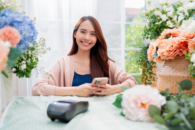 Retrato Asia Mujer florista sonrisa arreglando flores en una tienda de flores Tienda de diseño de flores felicidad sonriente jovencita haciendo jarrón de flores para los clientes que preparan el trabajo de flores desde el negocio en casa