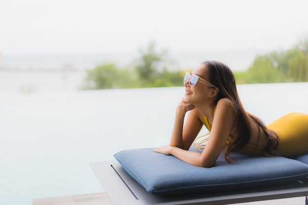 Foto gratuita retrato asiática hermosa joven feliz sonrisa relajarse en la piscina al aire libre en vacaciones