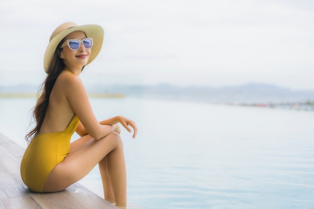 Foto gratuita retrato asiática hermosa joven feliz sonrisa relajarse en la piscina al aire libre en vacaciones