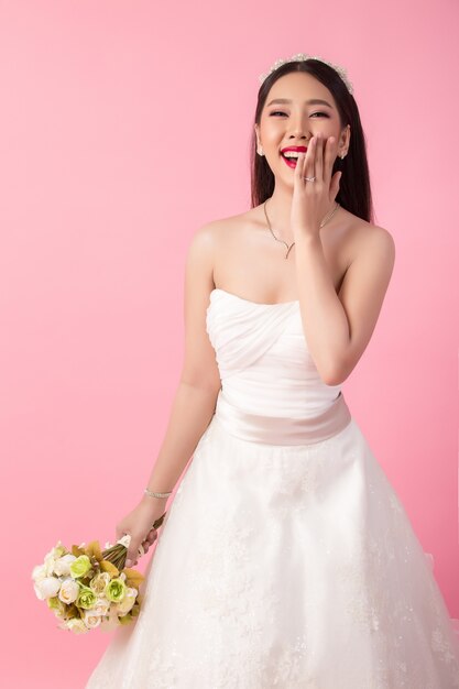 Retrato asiático hermoso de la novia en estudio rosado