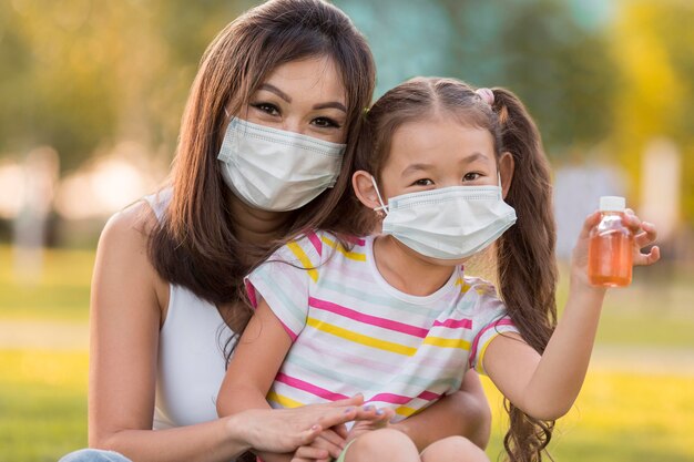 Retrato, de, asiático, madre e hija, con, mascarillas