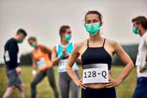 Foto gratuita retrato de atleta femenina con mascarilla mientras participa en una carrera de maratón durante la pandemia de covid19