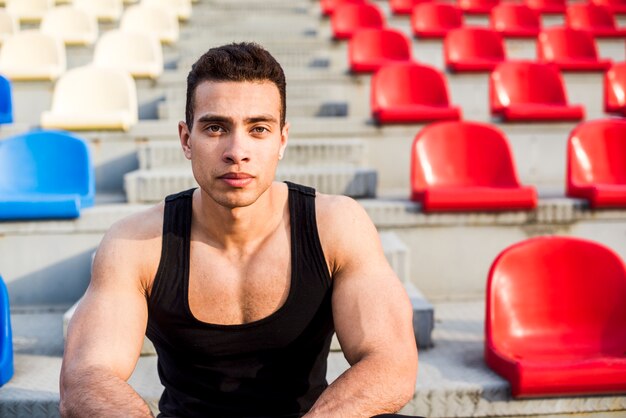 Retrato de un atleta masculino musculoso mirando a cámara