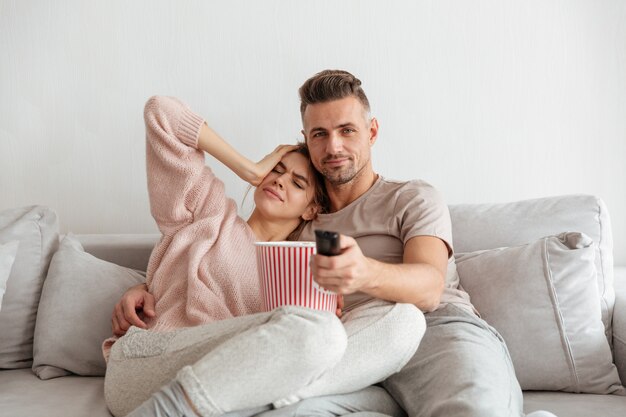 Retrato de una atractiva joven pareja comiendo palomitas de maíz