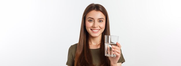Retrato de una atractiva mujer caucásica sonriente aislada en un estudio blanco disparó agua potable