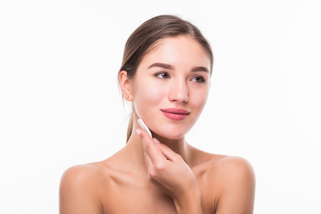 Retrato de atractiva mujer caucásica sonriente limpiando su rostro aislado en la pared blanca