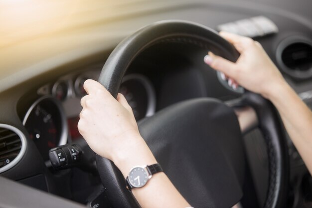 Retrato de una atractiva mujer sonriente conducir un coche