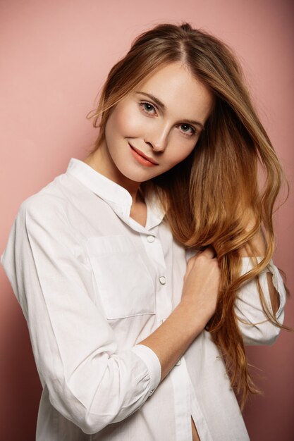 Retrato atractivo de la muchacha en una camisa blanca