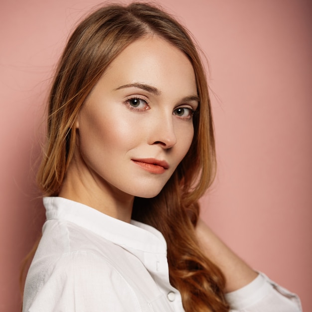 Retrato atractivo de la muchacha en una camisa blanca