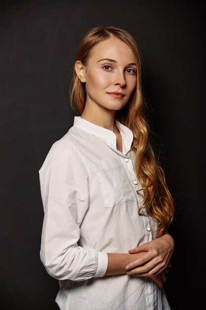 Retrato atractivo de la muchacha en una camisa blanca