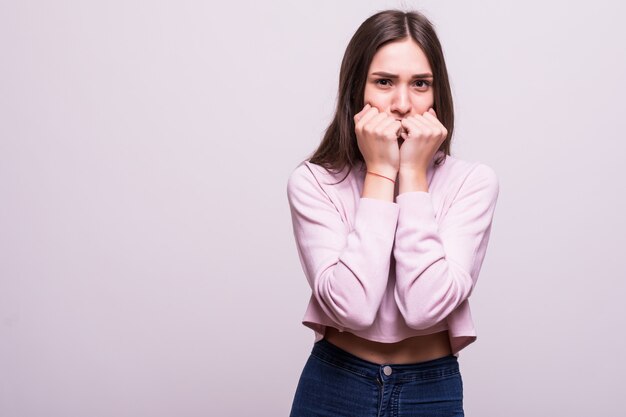 Retrato de atractivo sorprendido emocionado asustado gritando adolescente, cogidos de la mano en la cabeza, boca abierta aislada sobre fondo blanco