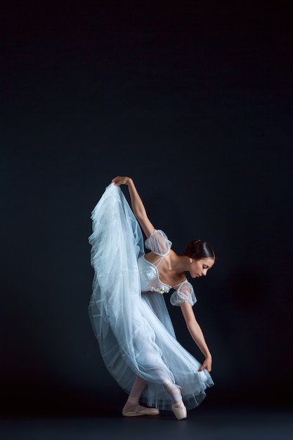 Retrato de la bailarina clásica en vestido blanco sobre negro