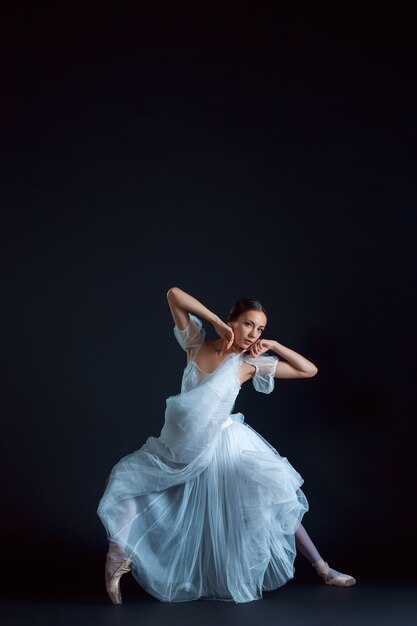 Retrato de la bailarina clásica en vestido blanco sobre negro