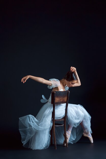 Retrato de la bailarina clásica en vestido blanco sobre negro