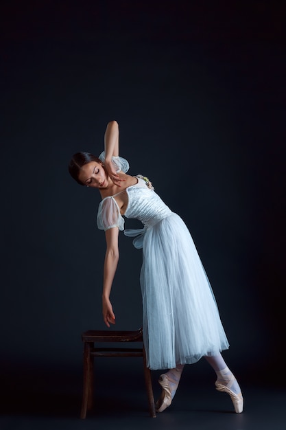 Retrato de la bailarina clásica en vestido blanco sobre negro