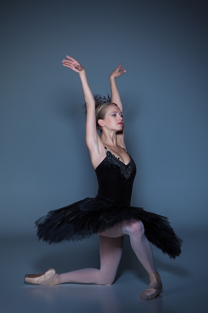 Retrato de la bailarina en el papel de un cisne negro sobre fondo azul.
