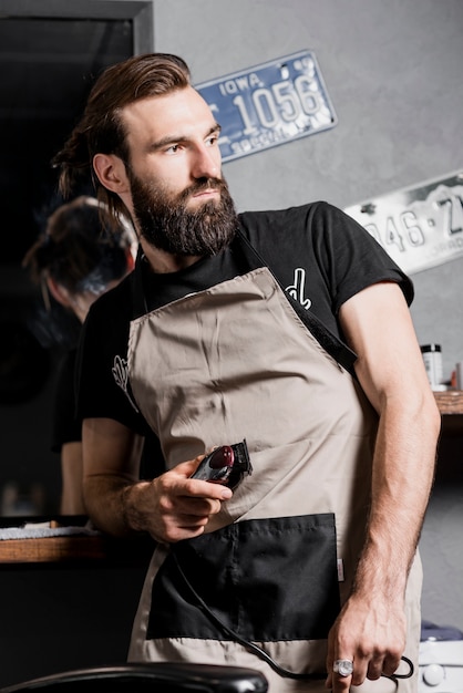 Retrato de un barbero con trimmer eléctrico