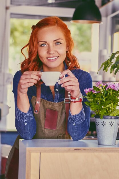 Retrato de una barista pelirroja en una pequeña cafetería.