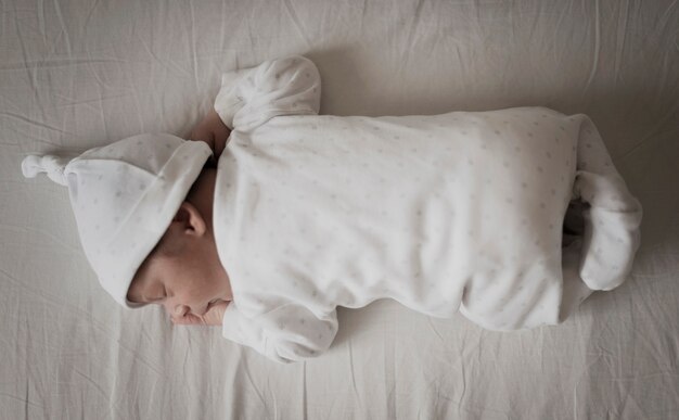 Retrato de bebé durmiendo en sábanas blancas