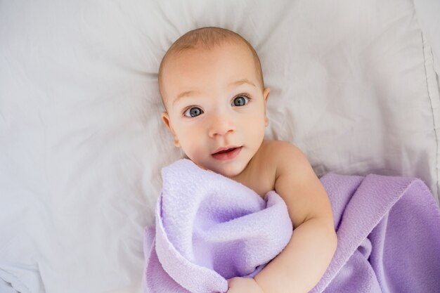 Retrato del bebé que se relaja en cama