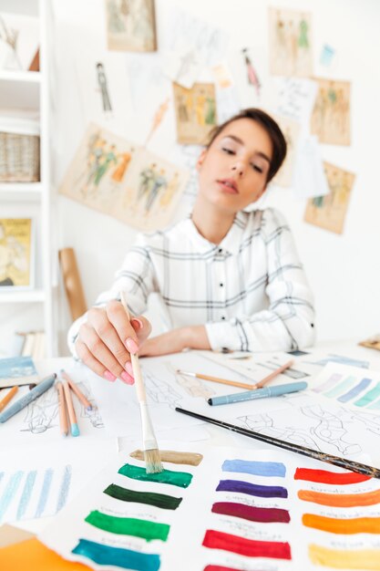 Retrato de una bella diseñadora de moda mujer que trabaja en el taller