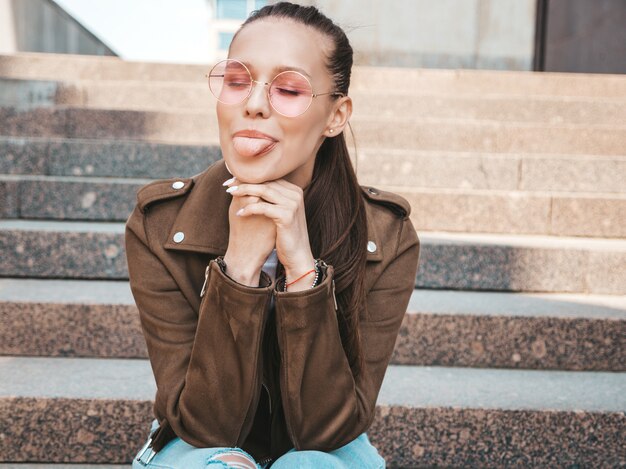 Retrato de la bella modelo morena sonriente vestida con ropa de chaqueta hipster de verano