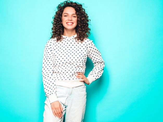 Retrato de la bella modelo sonriente con peinado afro rizos vestido con ropa hipster de verano. Mujer divertida y positiva de moda con capucha blanca